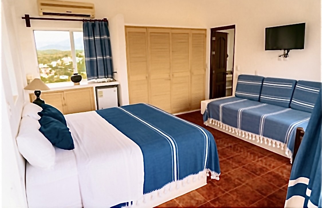 Cozy bedroom with blue accents, tiled floors, and a window view.